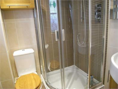 EN-SUITE SHOWER 5'2" x 5'0" (157m x 152m ) Opaque double glazed window with lead lights to the front elevation, fully tiled from floor to ceiling, corner contemporary style hand basin with a vanity