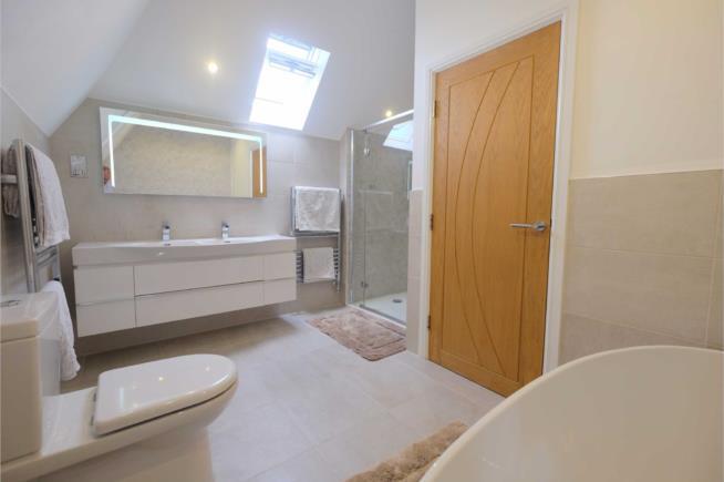with an oval double-ended bath with waterfall tap and shower head fitting, his-and-her's wash basins set in a basin, a WC and a separate shower cubicle Bedroom Two 14'8 x 9'9 (447m x 297m) French