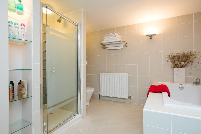 15m) Comprising tiled panelled bath with mixer tap, contemporary stainless steel sink unit with glass shelf, low flush wc, fully tiled shower cubicle with thermostatically controlled Hansgrohe shower