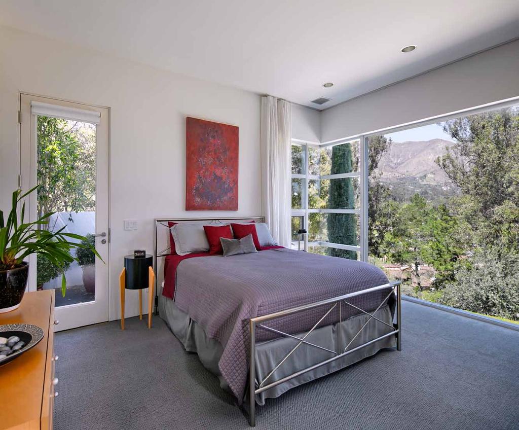 The guest bedrooms feature frameless corner windows with panoramic mountain and valley views.