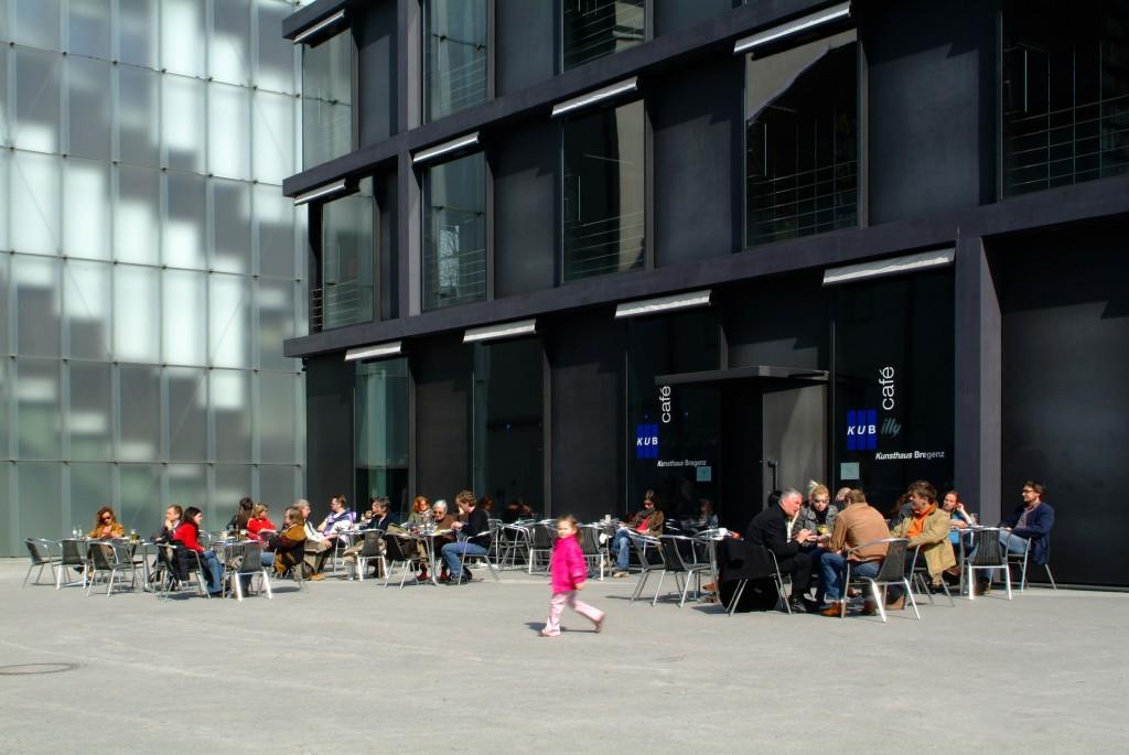 in exposed black concrete as well as the black square in front of the café, where visitors to the KUB Café prefer to sit at the round tables when the weather is good At night, the café turns into a