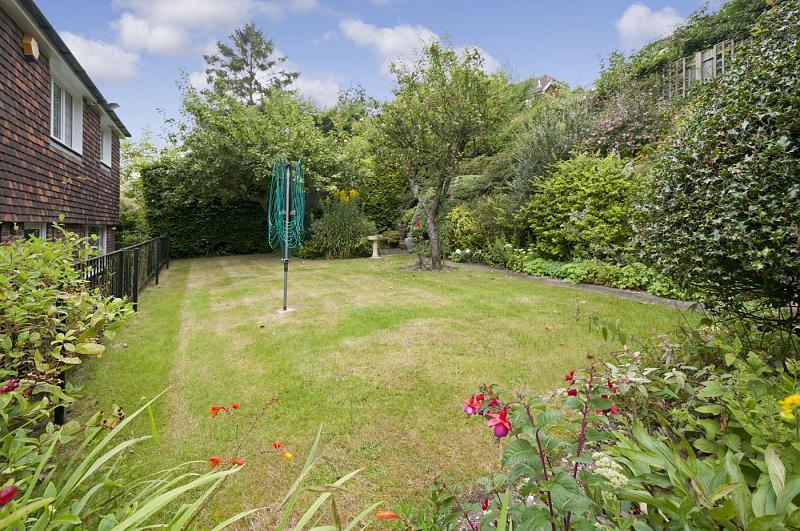 The rear garden is spilt over three different levels, with mature flower beds, a south facing patio and a wooden summer house.