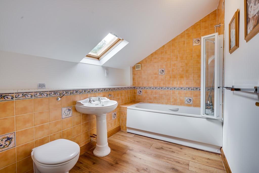 16m) with pitched ceiling, complementary part tiled walls, display shelf and white 3 piece suite comprising low flush WC with concealed cistern, pedestal wash hand basin and panelled bath with Mira