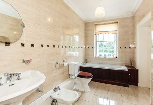 EN SUITE SHOWER ROOM Refurbished with corner cubicle with shower, vanity unit with large bowl, storage cabinets, display window with pelmet lighting, cabinet and low level wc.