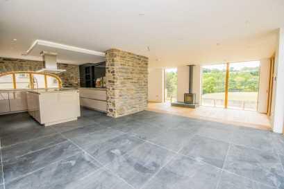 Riven slate floor which extends into the adjoining dining area, feature exposed stonework to the majority with arched oak framed window to the rear elevation. DINING AREA 4.