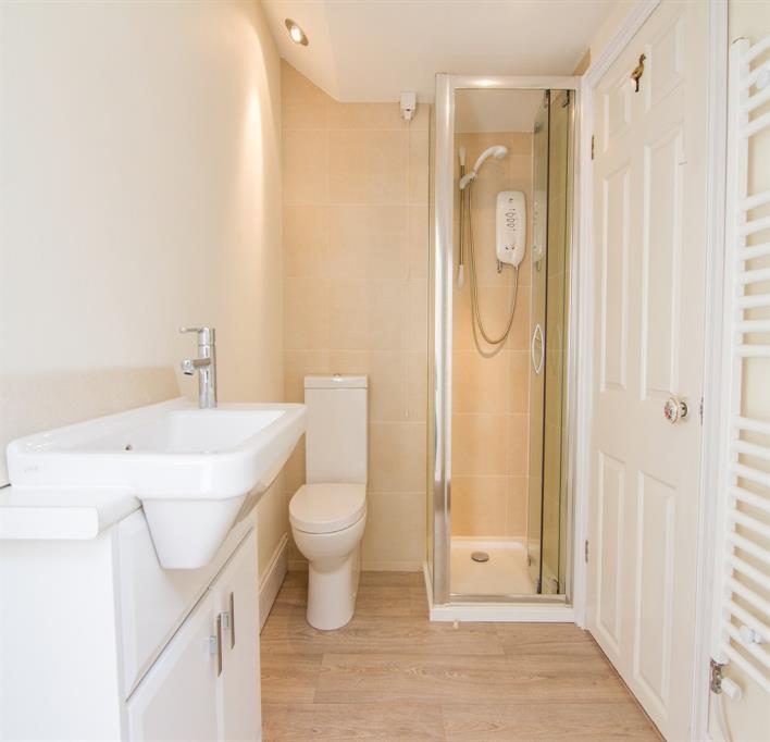 tiled walls, ceramic tiled floor, slim line wc, panel bath with chrome hand grips, chrome mixer taps and shower fitment, stylish chrome towel rail/radiator, ceiling with spot lights, double glazed