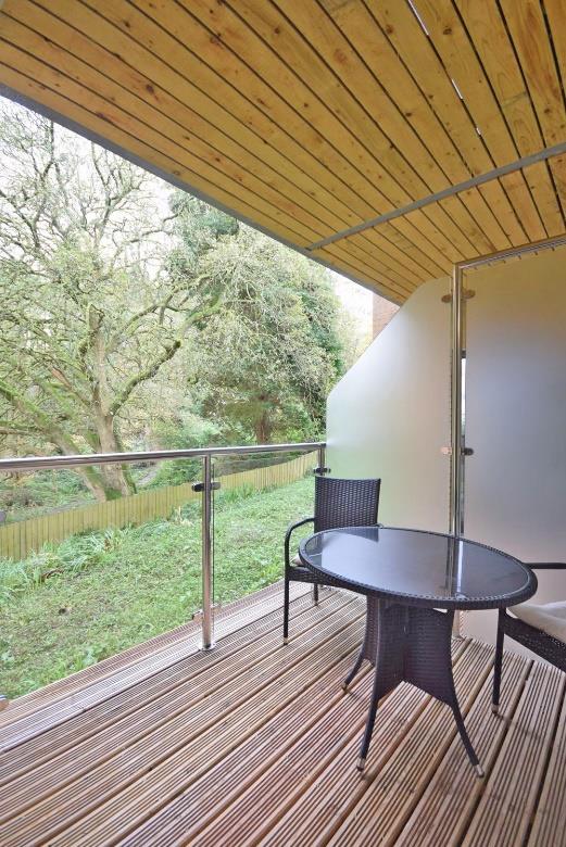A dual aspect room with a large double glazed picture window on one side overlooking woodland.