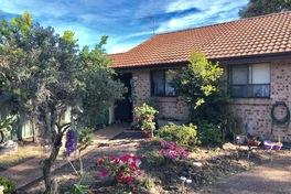 both entries. Pleasant, light filled lounge has large sliding glass doors that open onto the front verandah. Off the dining room there is a good size timber kitchen with generous cupboard space.