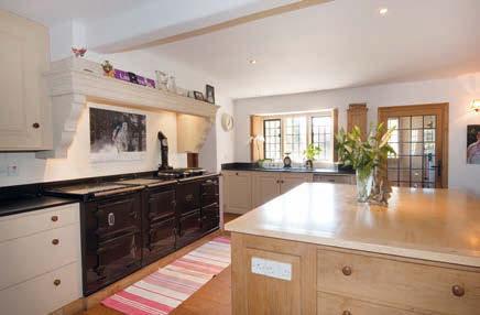 u Kitchen/breakfast room, a wonderful family kitchen with oak floor boards, shuttered stone mullion windows, four oven oilfired Aga, central work station, microwave, dishwasher and larder with larder