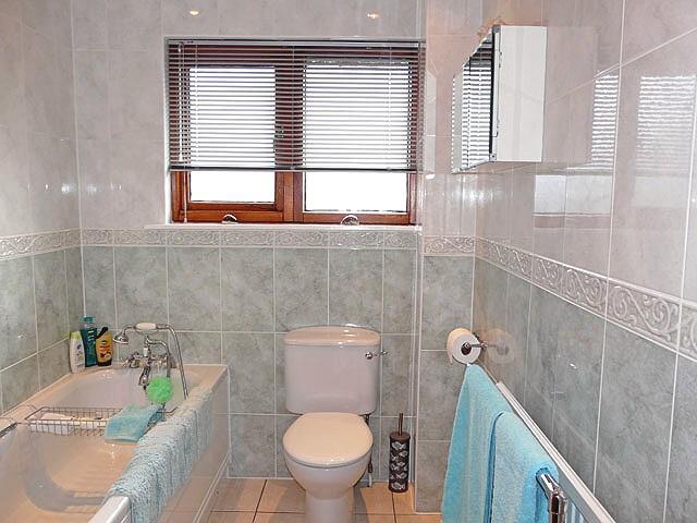 Heated towel rail/radiator and automatic extractor fan. Fully-tiled walls and floor. FAMILY BATHROOM 2.4m x 1.