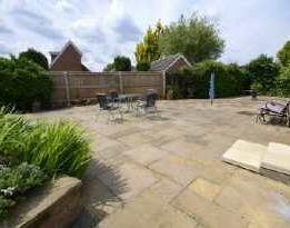 REAR GARDEN Low-maintenance and enjoying a degree of privacy being laid to Yorkstone paving stones with a range of mature shrubs and flower borders. Fencing to perimeters.