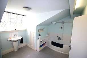 13m) A three piece suite with bath and shower over, pedestal wash basin and low level flush WC.