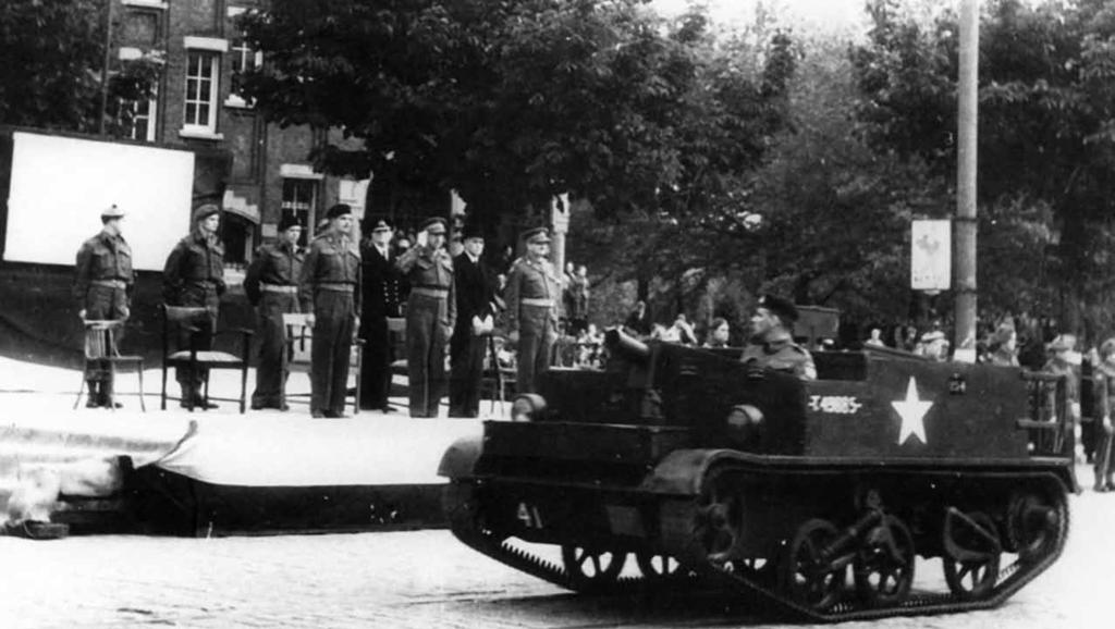 McGirr: Liberation of Holland A Bren carrier of the 4th PLDGs parades through Rotterdam, 9 June 1945. General H.D.G Crerar, commander of First Canadian Army (6th from left) takes the salute.