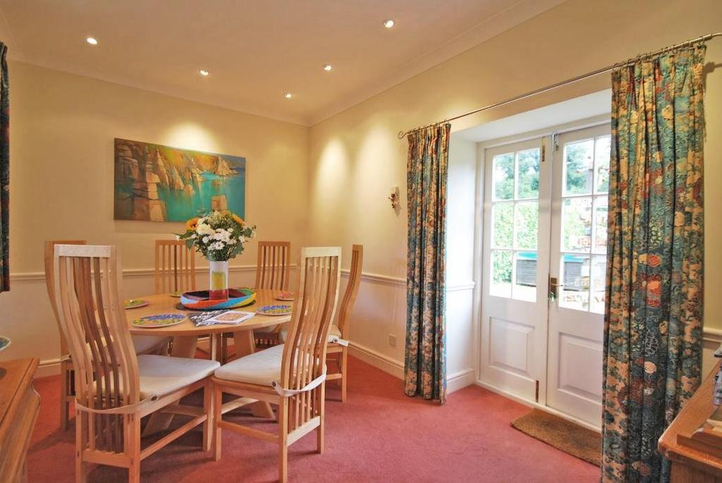 A superb dual aspect room with small pane wooden windows and small pane double doors opening out onto communal front gardens and private east facing gardens, feature fireplace with wrought iron multi