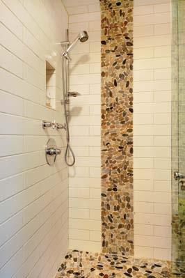 BOTTOM: Earth-toned pebbles intersect wall tiles in the shower.