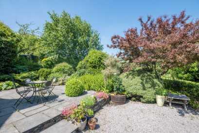 REAR GARDEN To the rear of the house is a very private and secluded paved patio, also with established flower and shrub borders together with steps leading up to a