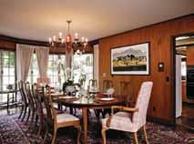 In the stately main house, a series of elegant rooms, paneled in rich walnut, open to a sunny, red brick