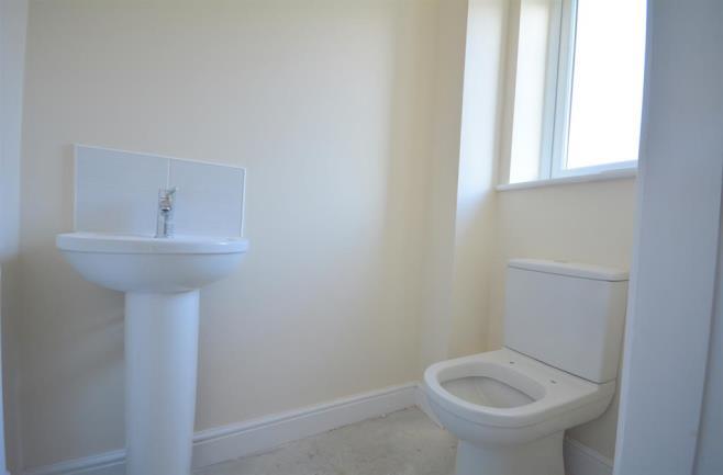 WC Consisting of a low level WC, wash hand basin and opaque window to the front elevation.