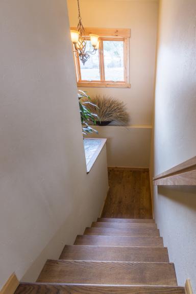 The lower level s main staircase is located by the front door. Big east facing windows, oak flooring, and a landing area with a display space makes the stairs inviting, light, and airy.