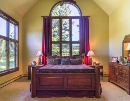 A double-story arched window, matching the one in the formal living room, opens up to