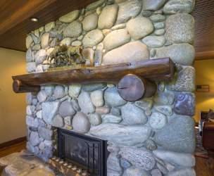 The sizeable log mantle above the fireplace, the impressive conversation-piece moose antler chandelier, the timber detailing, and of course the views all add to the home s