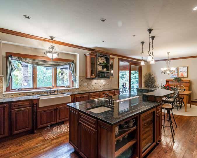 The gourmet kitchen is an expansive room that includes generous counter space, a large central island, and a dining room area.