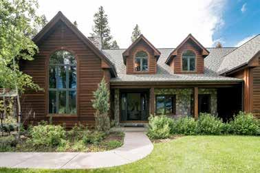 The rich redwood lap-siding exterior is accented by sage-forest green trim as well as river rock stone at the front and side door s covered porches.