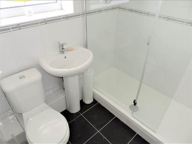 Bathroom: With shower cubicle, sink and WC, leaded stained window to side elevation and