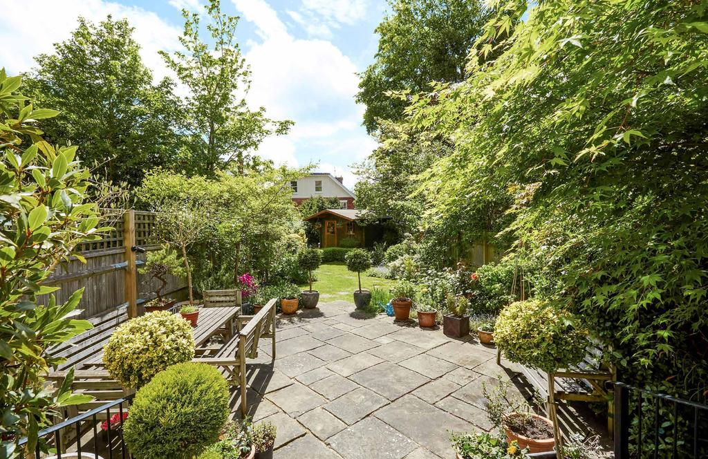 Outside The delightful south facing garden is a real feature of the property with its stone terrace flanked by mature borders including azaleas, camellias, roses and a Victoria plum.