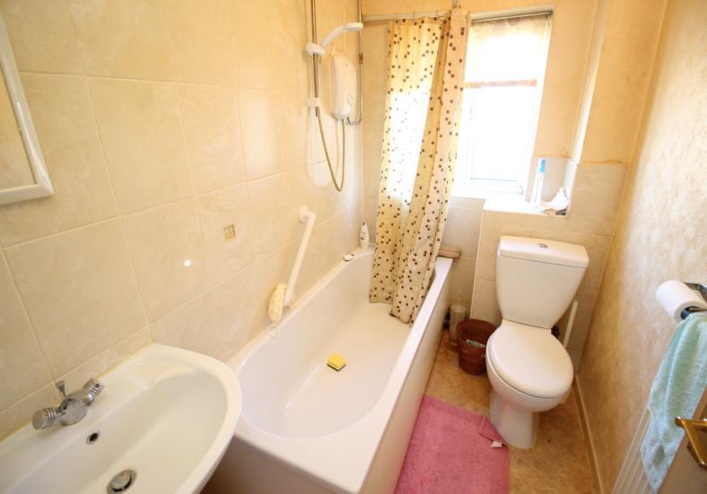 BATHROOM Panelled bath with electric shower above, fully tiled surrounding walls, pedestal wash basin, low flush w/c,