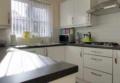 sink unit, mixer tap and dedicated drainage area. Four ring gas hob with extractor above. Integrated dishwasher. Integrated fridge and freezer unit.