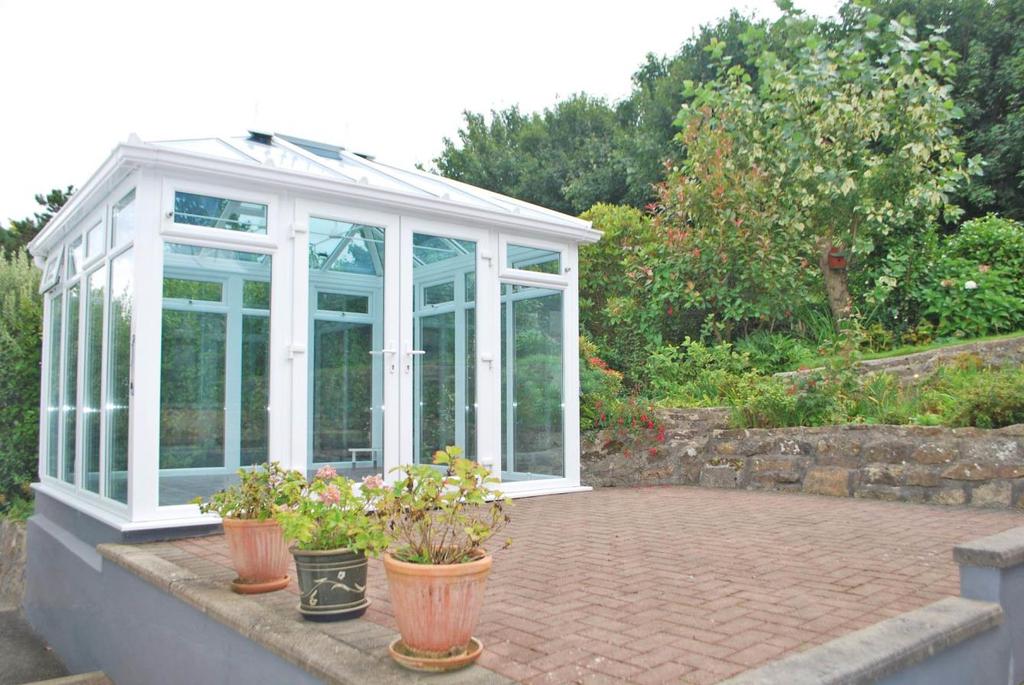 6 GARDEN ROOM which also enjoys the views over the sea and beyond. To the side and rear are a number of borders and beds, a small area of lane, greenhouse and garden shed with further seating areas.