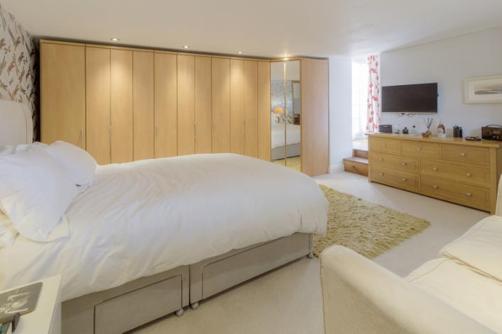 First Floor An open plan oak staircase leads to the third bedroom with fitted wardrobes and conservation skylight, en-suite shower room fitted with Travertine tiles and conservation skylight.