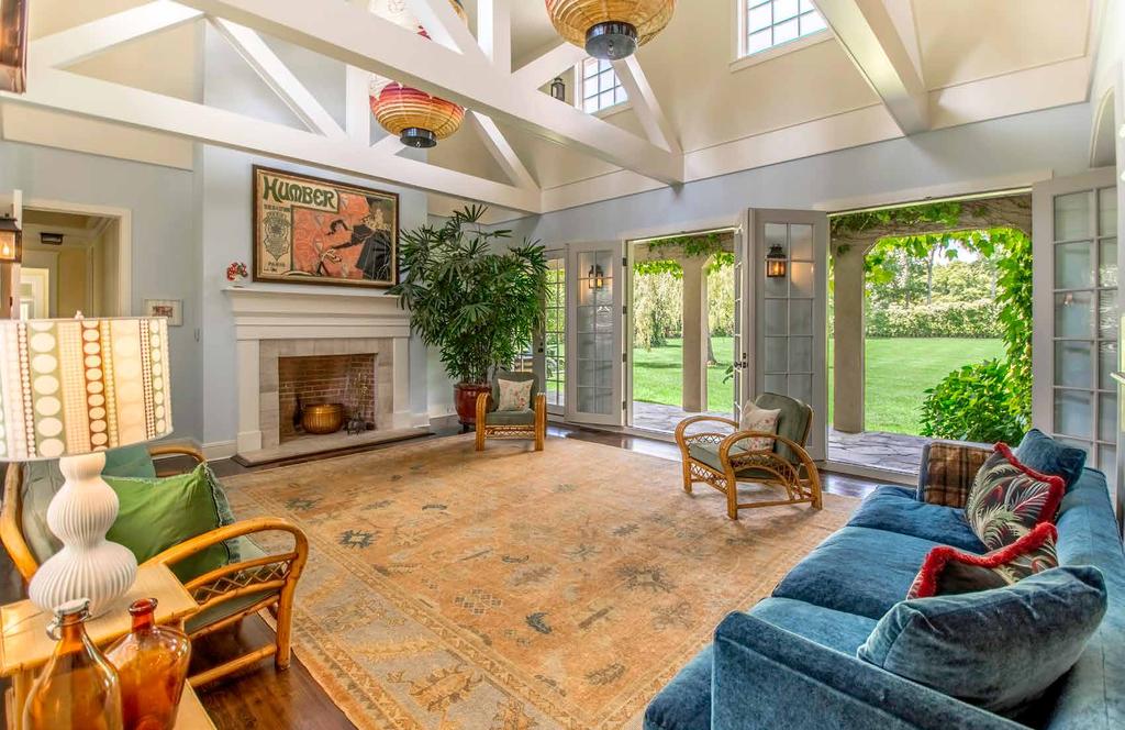 LIVING ROOM The living room features high ceilings with exposed wooden beams and three elegant sets of