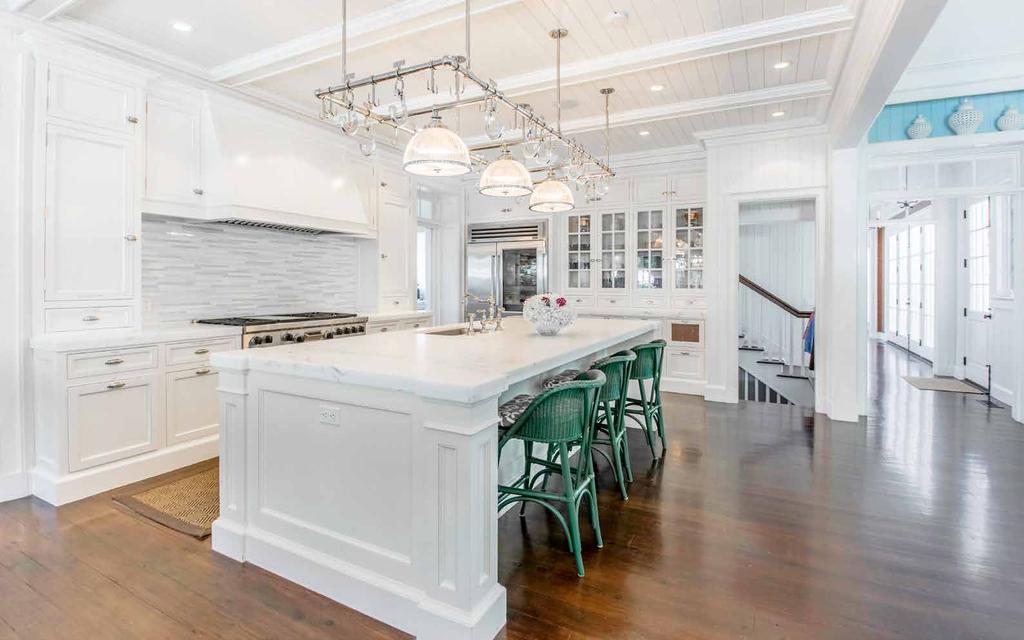 KITCHEN The country-style kitchen is open to the spacious yet informal great room and is finished with a white marble island, custom built-in cabinetry, granite counters, and