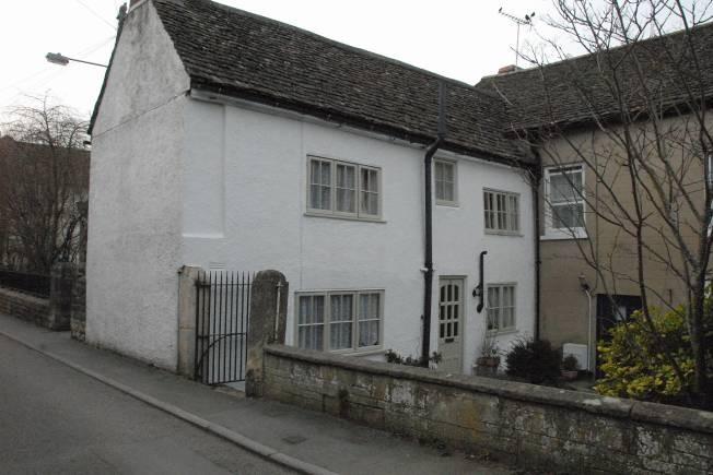 Two cottages to west of Abbey Gate-house and forming part of fabric. Core of early C16, altered to form cottages. Ashlar, hipped Cotswold stone slate roof, 2 large brick ridge stacks.