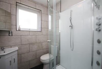 corner wash hand basin in vanity unit, close coupled wc, heated towel rail, extractor fan, mirrored cabinet,