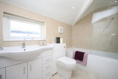 tap, wc with hidden cistern, extensive ceramic tiled surround, heated towel rail, extractor