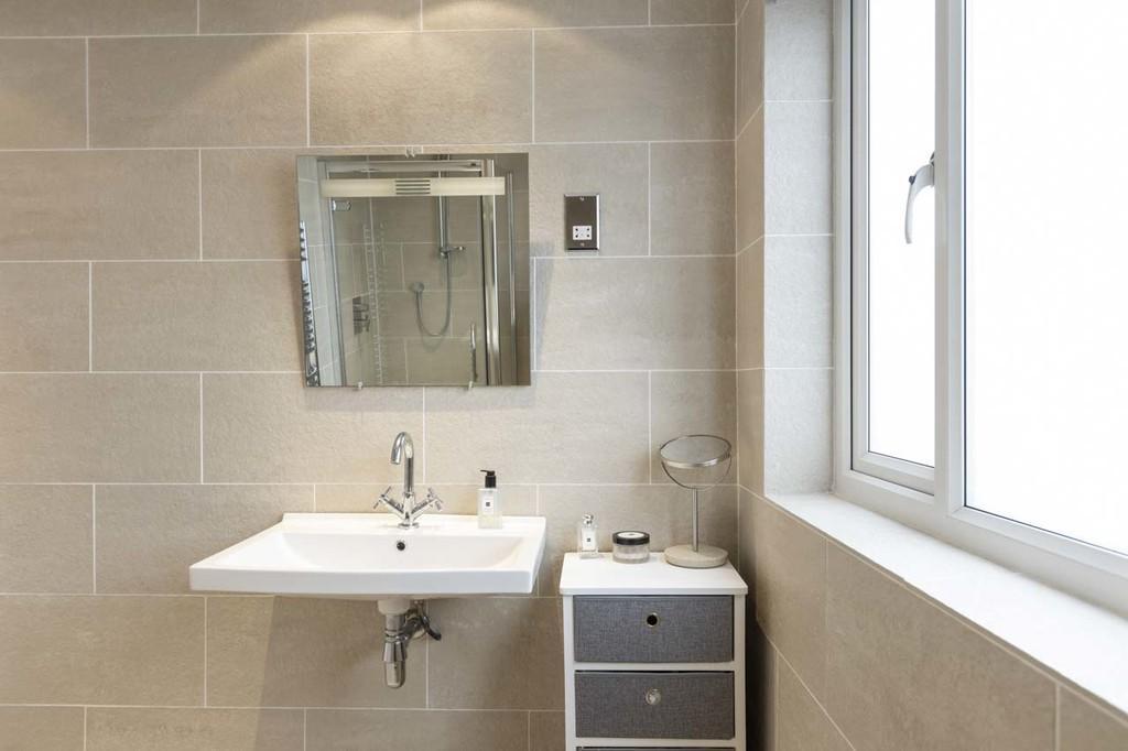 FAMILY BATHROOM Modern white suite comprising low flush w.c. Pedestal wash hand basin with mixer tap.