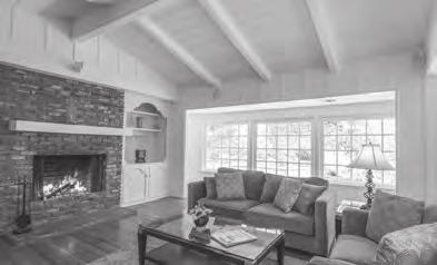 Double door entry leads to living room with cathedral ceilings, beams and fireplace.