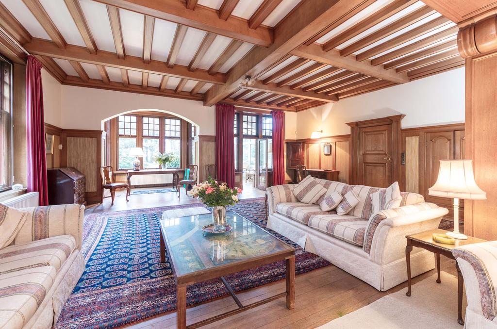 home. The ground floor begins with a magnificent reception hall with pitch pine floor, beautiful wood panelling, high ceilings, stunning cornicing and an appropriately imposing fireplace with a stone