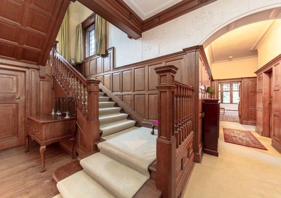 At the far end a wide wooden staircase leads up to the first floor.