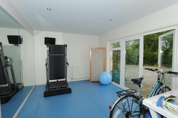 GYM 4.47m (14'8) x 3.33m (10'11) Glazed patio doors to garden; non slip vinyl floor; 12 volt ceiling lights; large wall mirror; high level double power points and tv aerial socket.