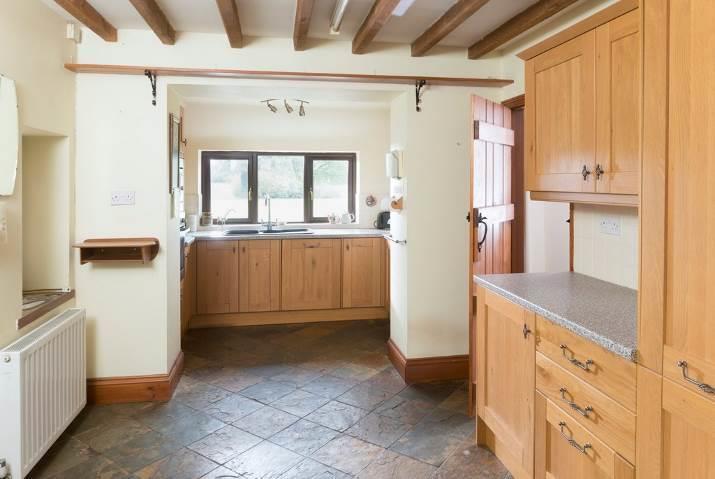 splashbacks, slate floor. Opening to DINING ROOM with tiled floor. UTILITY ROOM with single bowl, single drainer sink unit with monobloc mixer taps over and cupboards beneath.