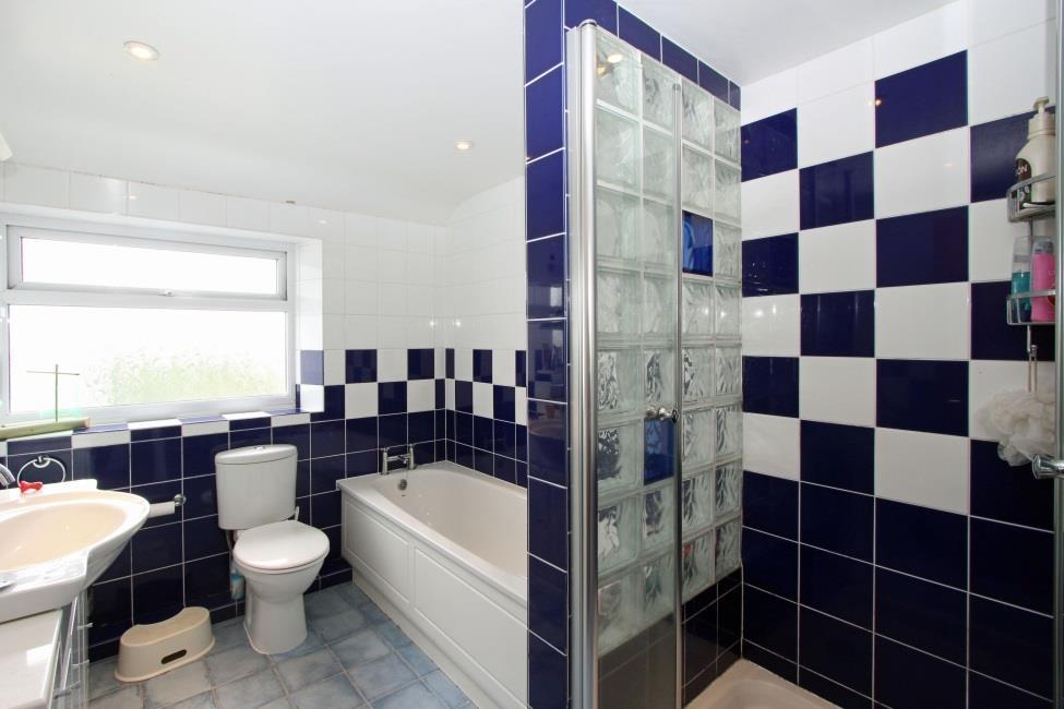 Sliding door to: En suite shower room 11 x 3 3 Fitted with a three piece white suite comprising shower cubicle,