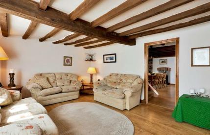 Character Sitting Room with exposed beams and Inglenook fireplace with supporting beams and brick working fireplace, laminate floor, windows to front and side, door to front.