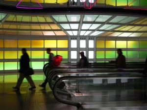length of the ceiling above two moving sidewalks, and is composed of white sections on either end with a rainbow of colors in between It is controlled by 3 different computers cycling through various