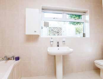 The fully tiled en-suite bathroom comprises a cream suite with bath, low level WC, wash