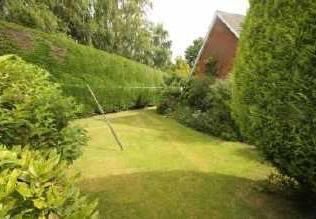 flower beds, mature trees and extensive lawned
