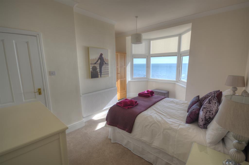 17m (13' 8") UPVC double glazed bay window to the front aspect with pull down blinds and beautiful panoramic views from Filey Brigg towards Flamborough Head, coving, radiator, feature fireplace with